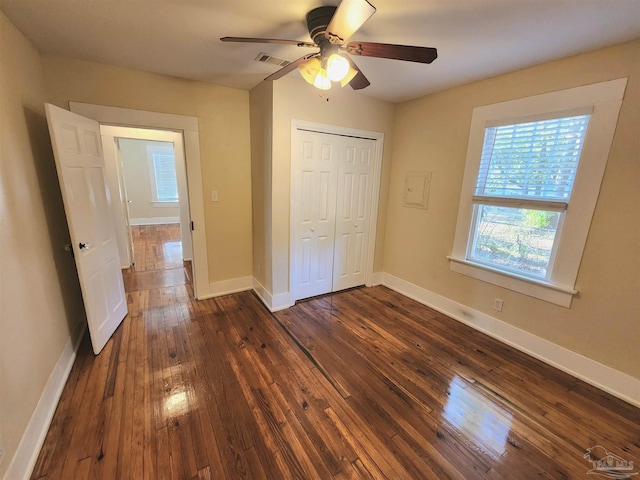 unfurnished bedroom with a ceiling fan, visible vents, baseboards, a closet, and dark wood finished floors