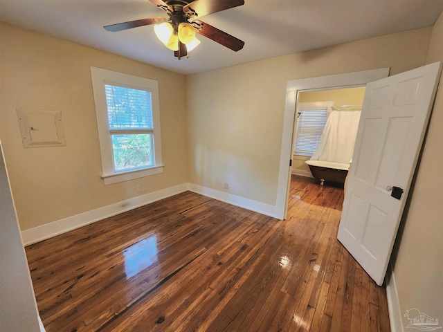 unfurnished bedroom with ceiling fan, dark wood finished floors, electric panel, and baseboards