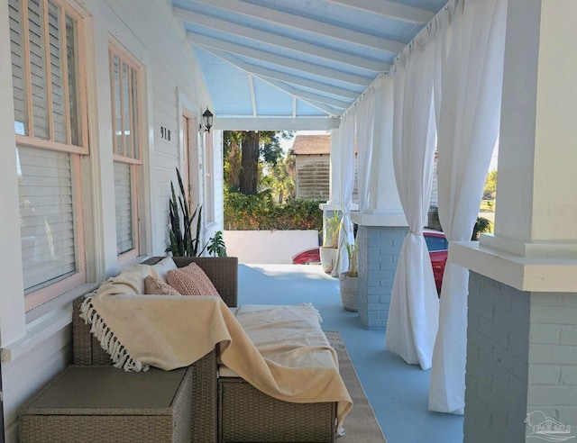 exterior space featuring vaulted ceiling with beams