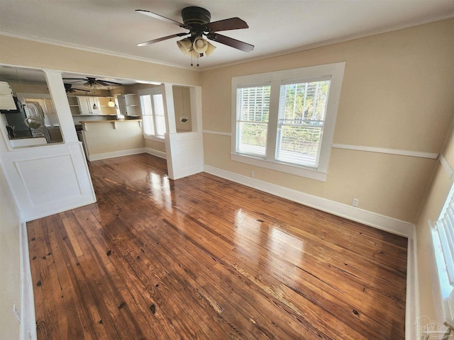 interior space featuring dark wood-style floors, crown molding, baseboards, and ceiling fan