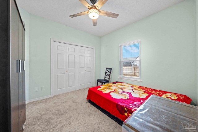 carpeted bedroom with a closet, ceiling fan, and a textured ceiling