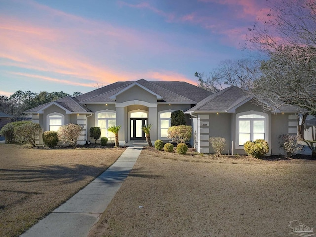 ranch-style home with a yard