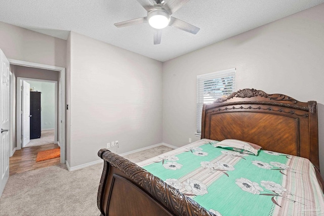 carpeted bedroom featuring a textured ceiling and ceiling fan