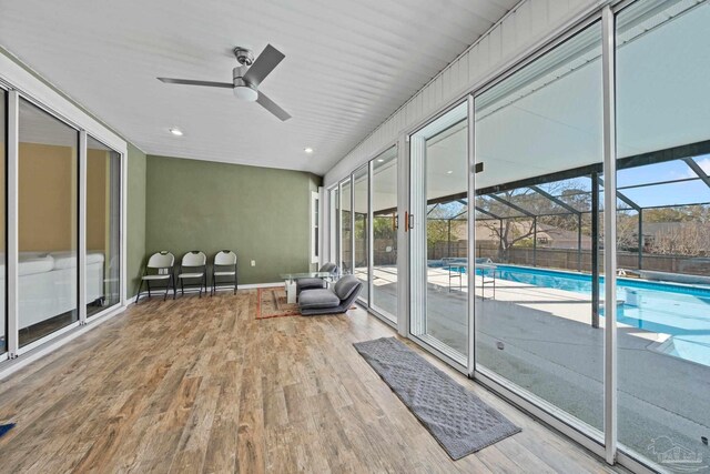 unfurnished sunroom with ceiling fan