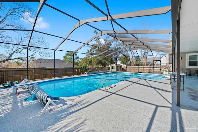 view of swimming pool with a patio, glass enclosure, and a shed