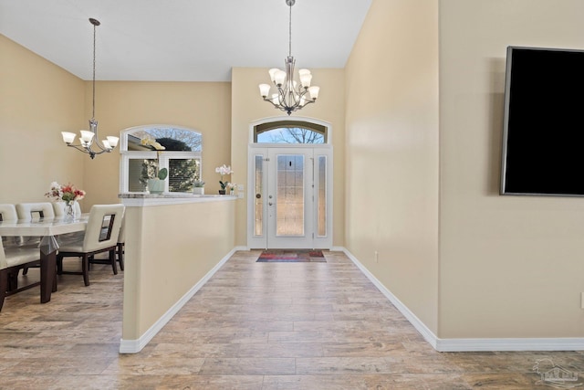 entrance foyer with an inviting chandelier, hardwood / wood-style flooring, and a towering ceiling