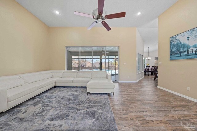 living room with ceiling fan, a textured ceiling, and wood-type flooring