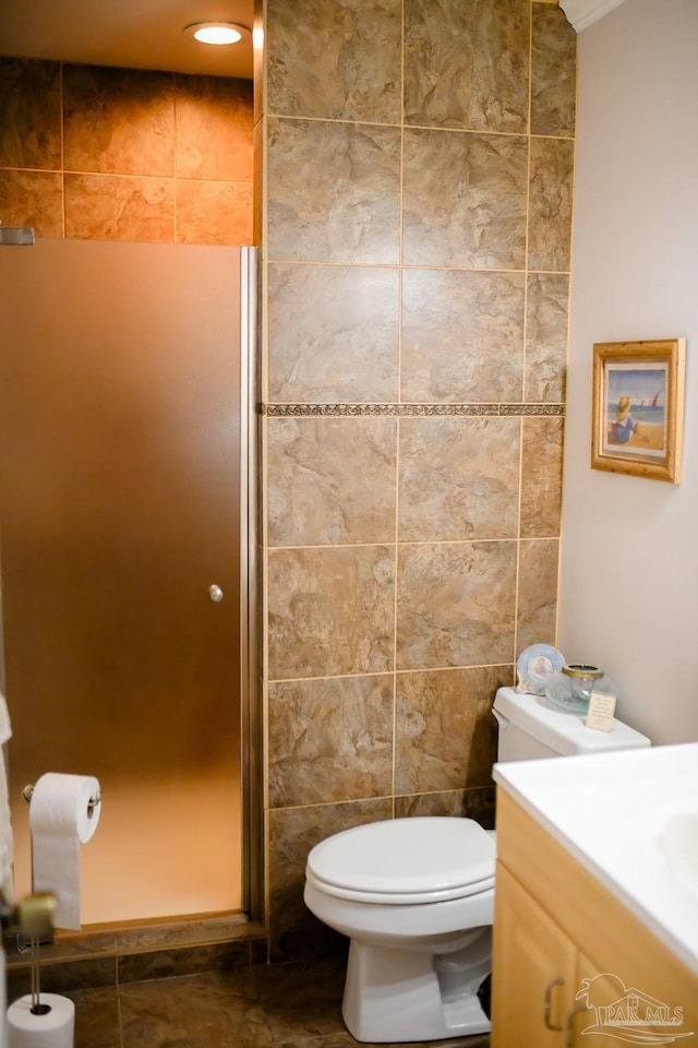 bathroom with vanity, toilet, tile walls, and walk in shower