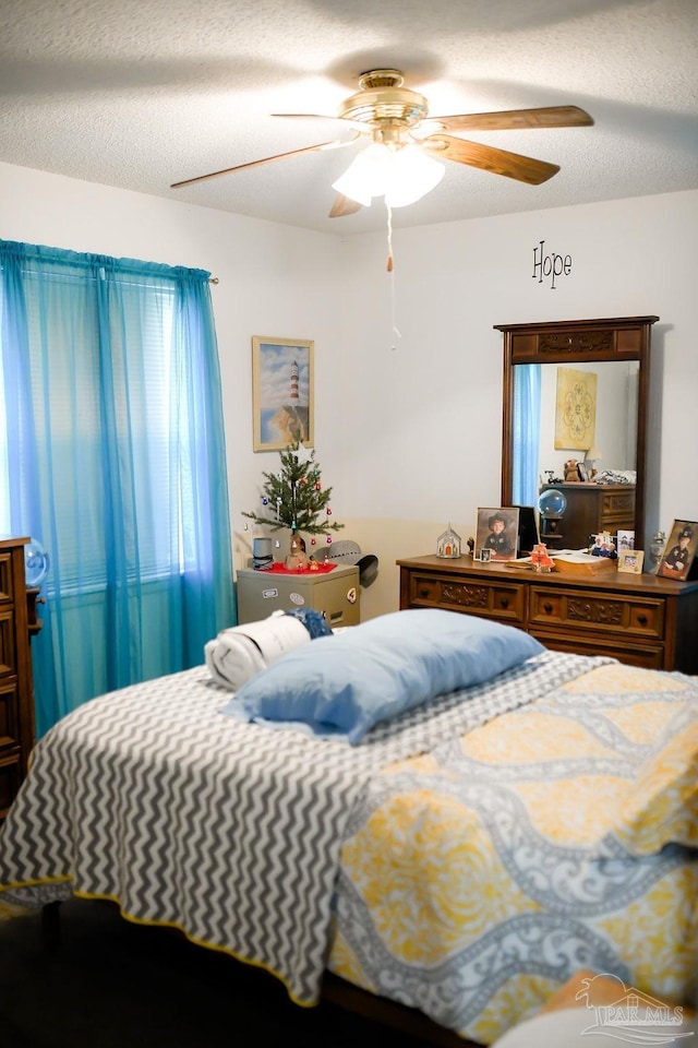 bedroom with a textured ceiling and ceiling fan