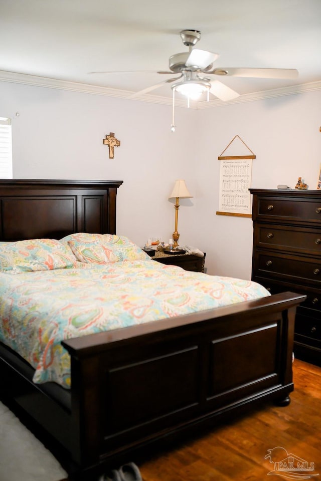 bedroom featuring dark hardwood / wood-style flooring, crown molding, and ceiling fan