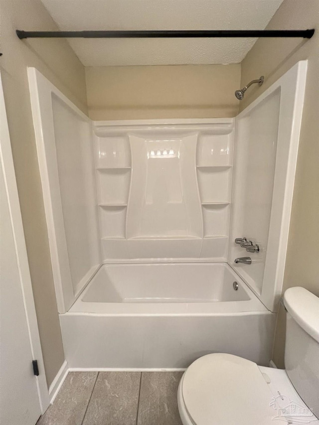 bathroom featuring shower / bathtub combination, toilet, and a textured ceiling