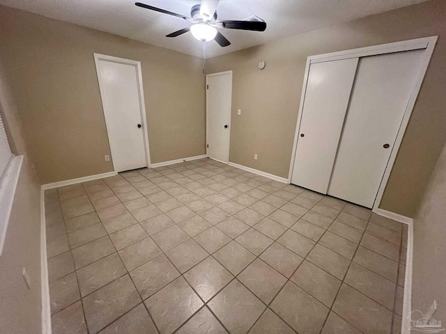 unfurnished bedroom featuring ceiling fan, a closet, and light tile patterned floors