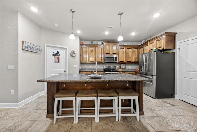 3920 Shady Grove Dr, Pace, FL 32571 - kitchen with appliances with stainless steel finishes, dark stone countertops, a sink, hanging light fixtures, and an island with sink