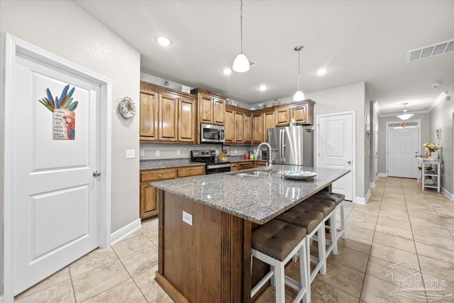 3920 Shady Grove Dr, Pace, FL 32571 - kitchen with appliances with stainless steel finishes, a sink, brown cabinets, a breakfast bar, and stone counters