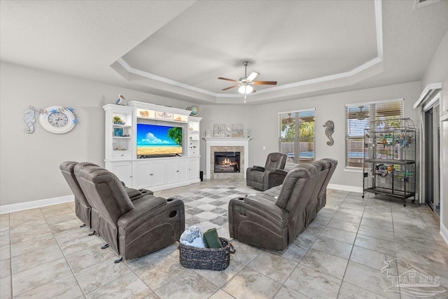 3920 Shady Grove Dr, Pace, FL 32571 - living room featuring a tray ceiling, a ceiling fan, a tile fireplace, baseboards, and ornamental molding