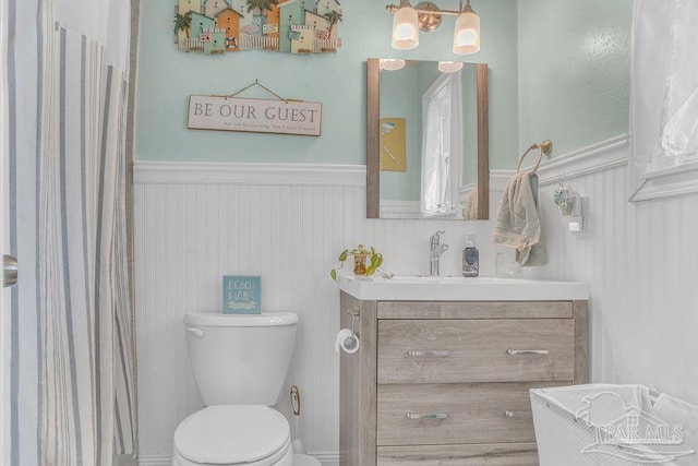 10443 Gulf Beach Hwy Unit 1, Pensacola, FL 32507 - full bathroom featuring a shower with curtain, a wainscoted wall, vanity, and toilet