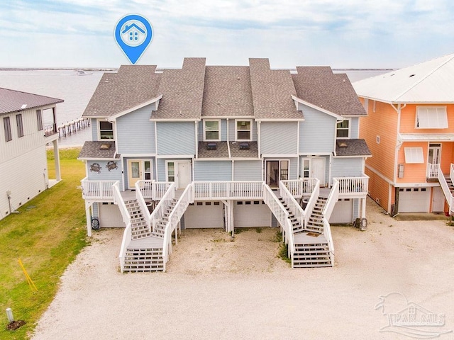10443 Gulf Beach Hwy Unit 1, Pensacola, FL 32507 - back of property featuring a garage, driveway, a shingled roof, and stairs