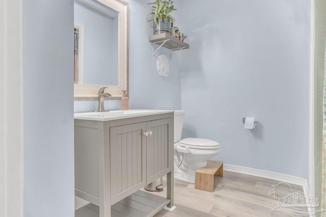 10443 Gulf Beach Hwy Unit 1, Pensacola, FL 32507 - bathroom featuring baseboards, toilet, vanity, and wood finished floors
