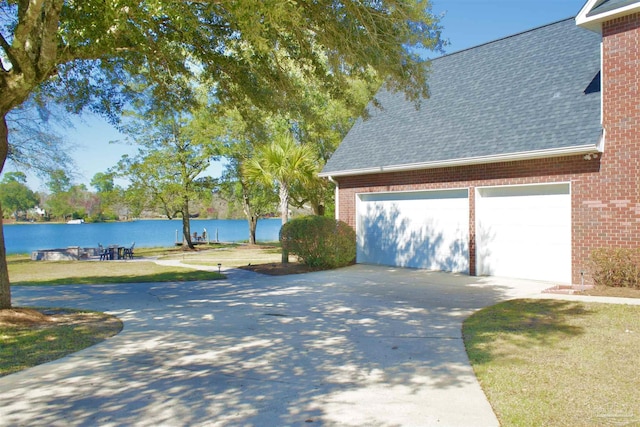 exterior space with concrete driveway and a water view