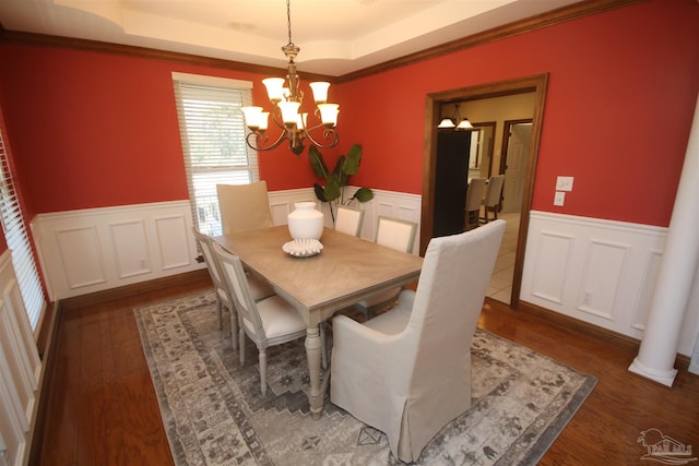 dining room featuring wainscoting, a raised ceiling, dark wood finished floors, and an inviting chandelier