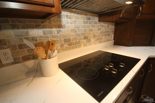 room details with custom exhaust hood and black electric stovetop