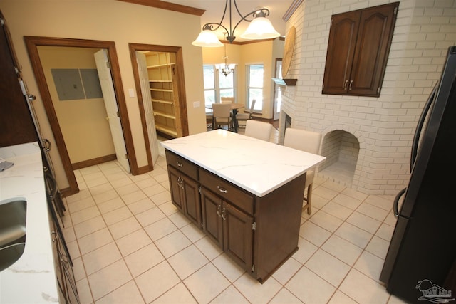 kitchen featuring a chandelier, light tile patterned flooring, freestanding refrigerator, and pendant lighting