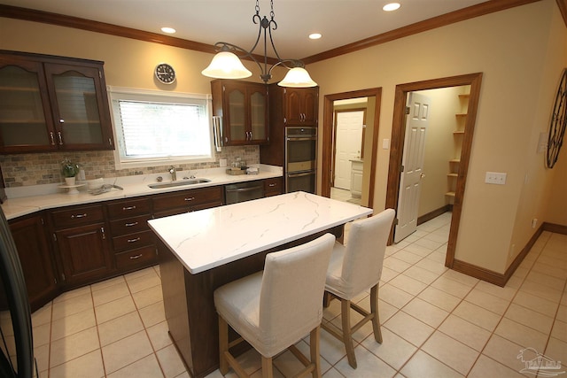 kitchen featuring a breakfast bar, light tile patterned floors, stainless steel appliances, and a sink