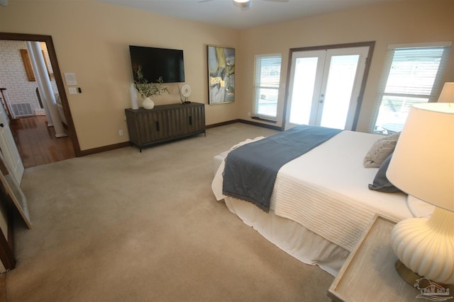 carpeted bedroom featuring french doors, multiple windows, and baseboards