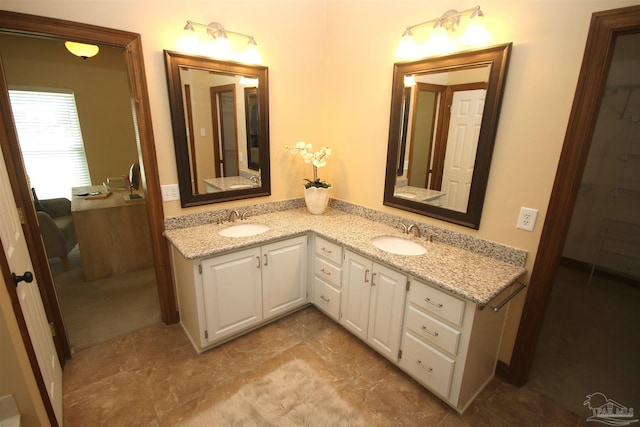 full bathroom with double vanity and a sink