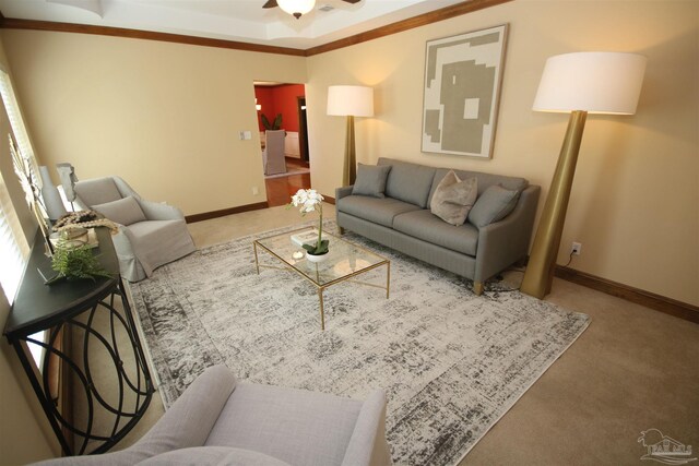 carpeted living area with baseboards and a ceiling fan