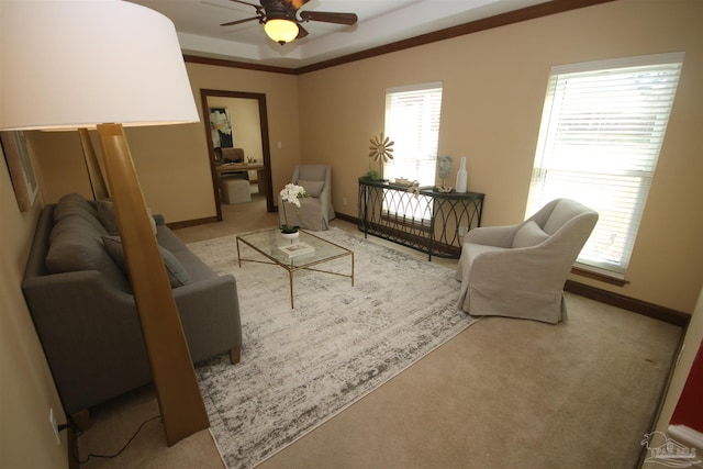 living room with carpet, a tray ceiling, ceiling fan, and baseboards