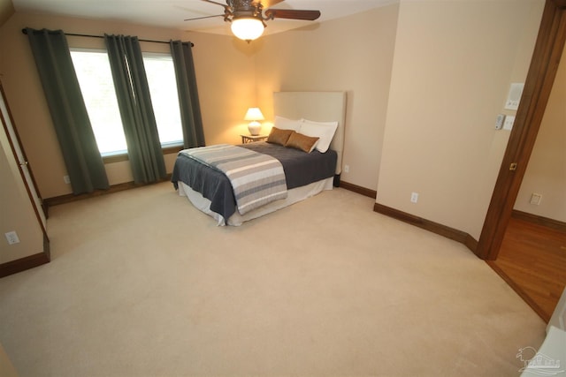 bedroom featuring a ceiling fan, light colored carpet, and baseboards