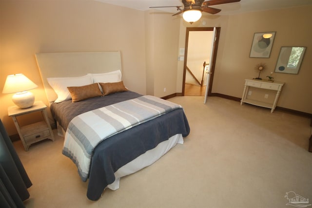 bedroom featuring light carpet, ceiling fan, and baseboards