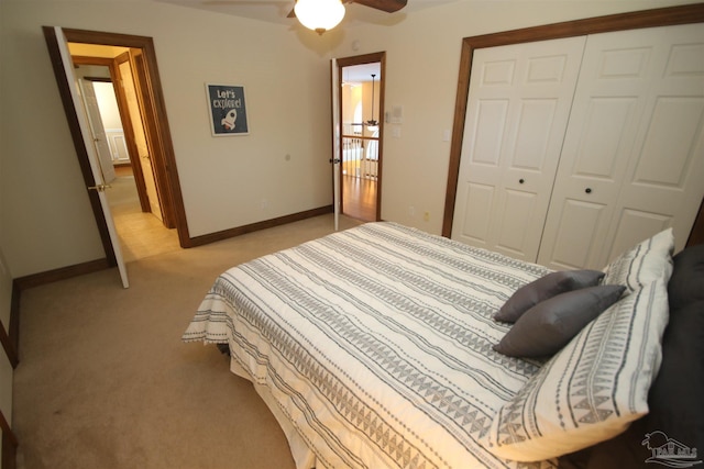 bedroom with baseboards, a closet, a ceiling fan, and light colored carpet