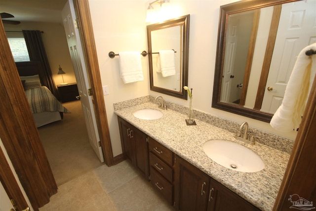 bathroom with ensuite bathroom, double vanity, tile patterned flooring, and a sink