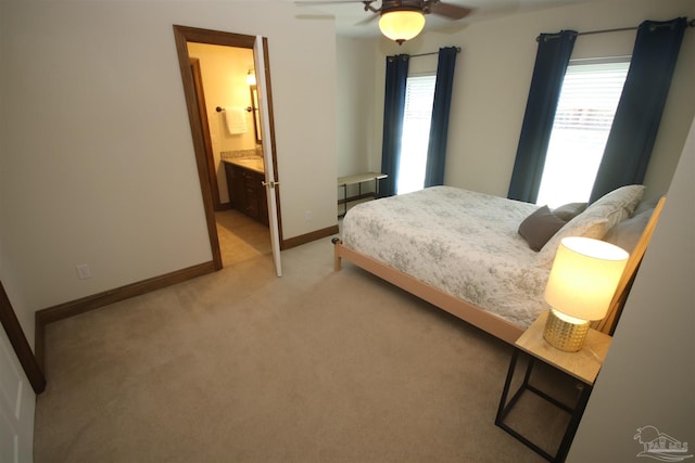 bedroom with baseboards, ceiling fan, connected bathroom, and light colored carpet