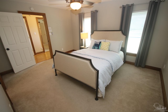 bedroom with a ceiling fan, light colored carpet, and baseboards