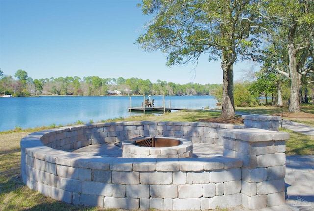 view of patio featuring an outdoor fire pit, a water view, and a boat dock