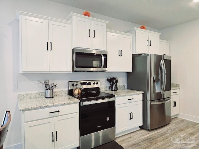 kitchen with light wood-type flooring, white cabinetry, and appliances with stainless steel finishes