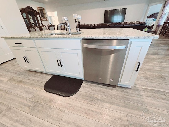 kitchen featuring dishwasher, light wood-style flooring, and a sink