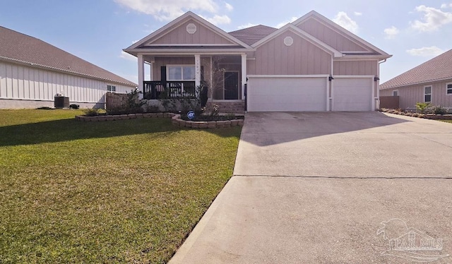 view of front of house with an attached garage, covered porch, concrete driveway, a front lawn, and board and batten siding