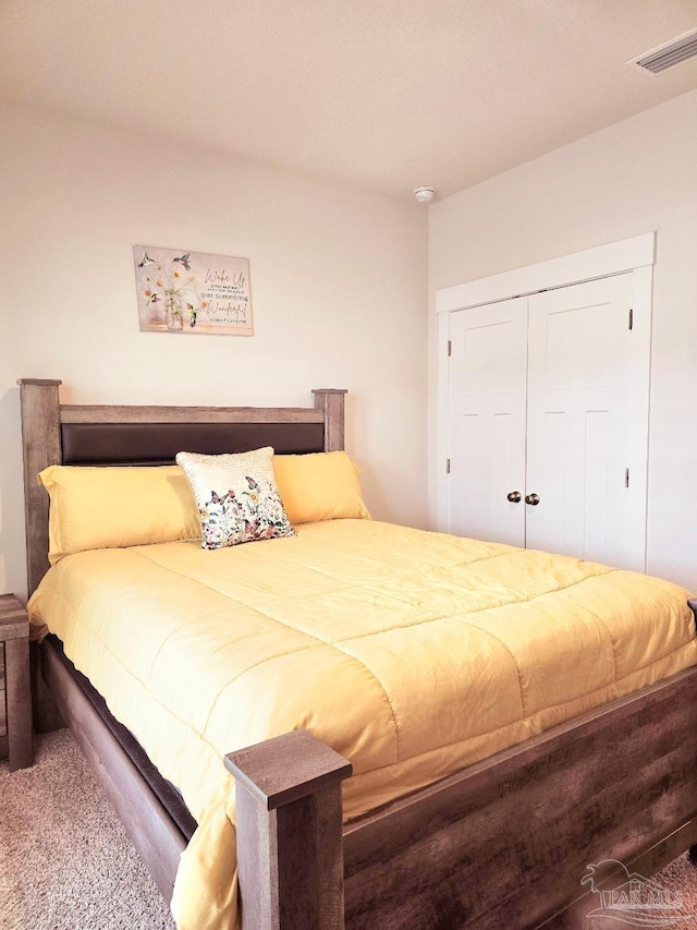 carpeted bedroom with a closet and visible vents