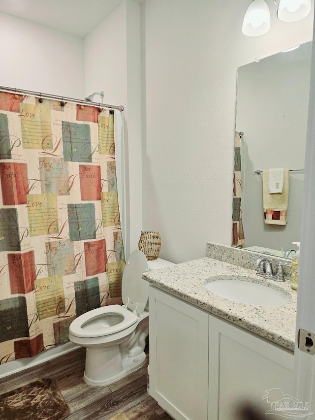 full bath featuring toilet, wood finished floors, and vanity