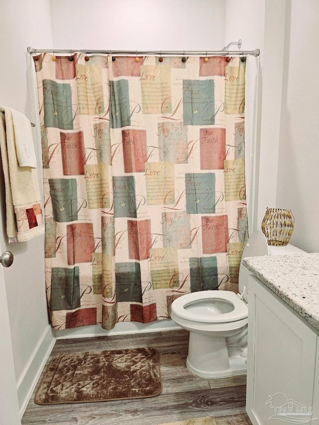 bathroom featuring a shower with shower curtain, vanity, toilet, and wood finished floors