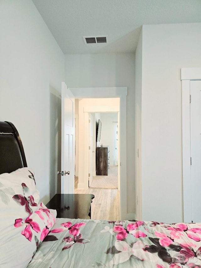 bedroom featuring wood finished floors and visible vents