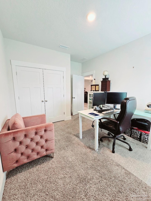 home office featuring a textured ceiling, visible vents, and carpet flooring