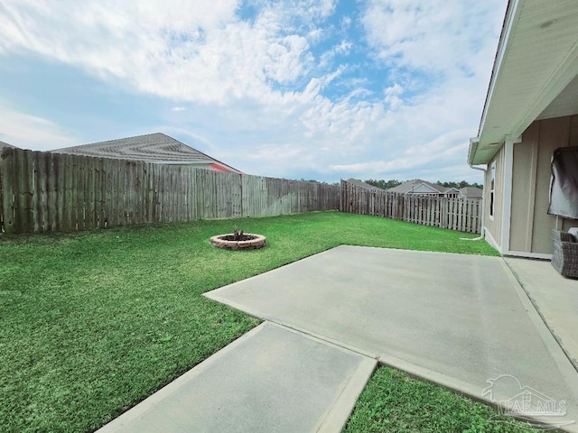 view of yard with an outdoor fire pit, a fenced backyard, and a patio