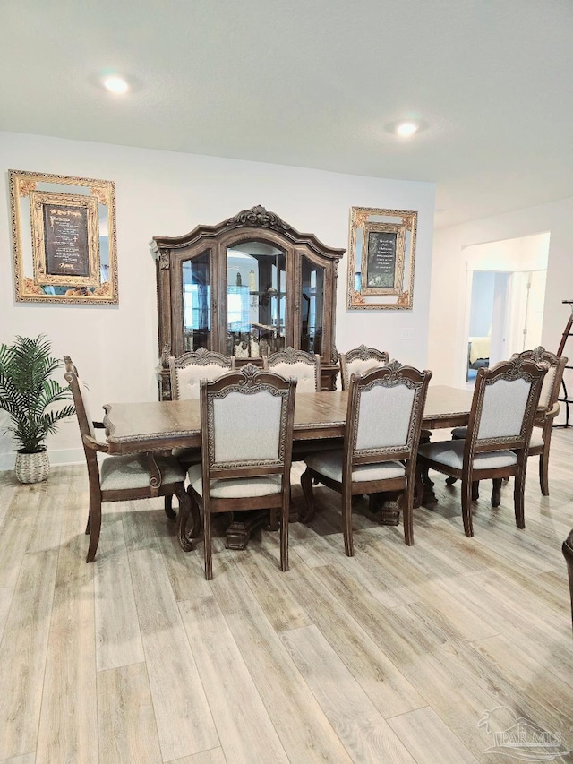 dining room featuring light wood-type flooring and baseboards