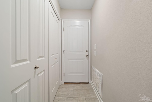 hall featuring light tile patterned floors