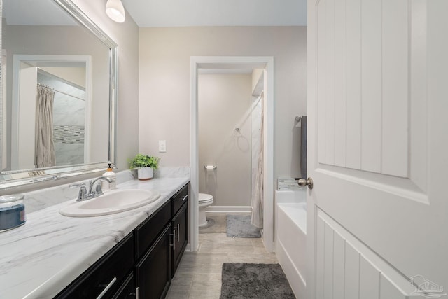 bathroom with vanity, toilet, and a tub to relax in